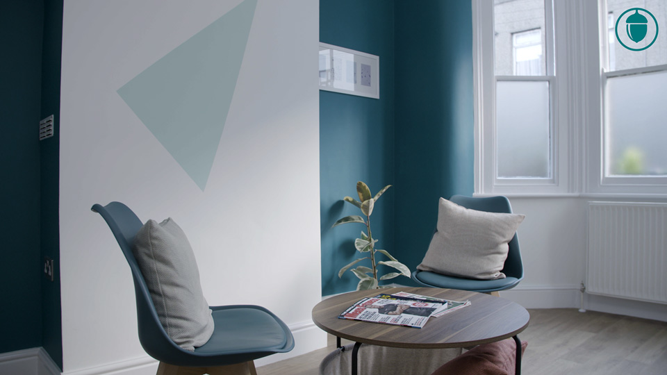 Cosy waiting room at Acorn Andrology clinic with modern chairs and a coffee table.