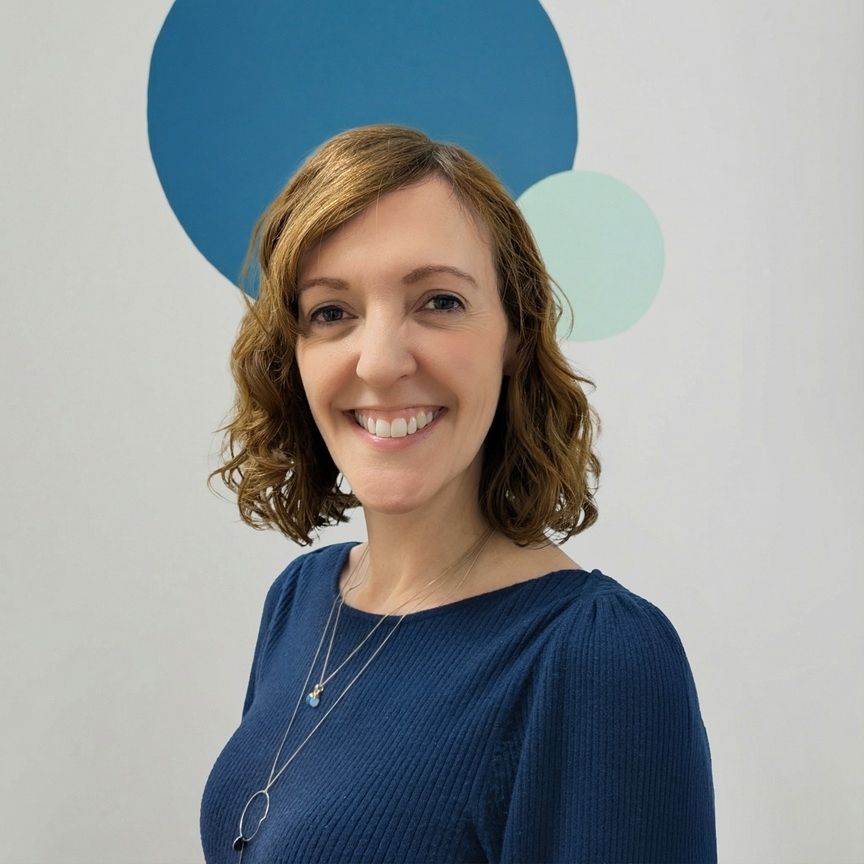 Laura, a clinical scientist and quality manager, smiling in a professional portrait against a minimalist background with blue circular shapes.